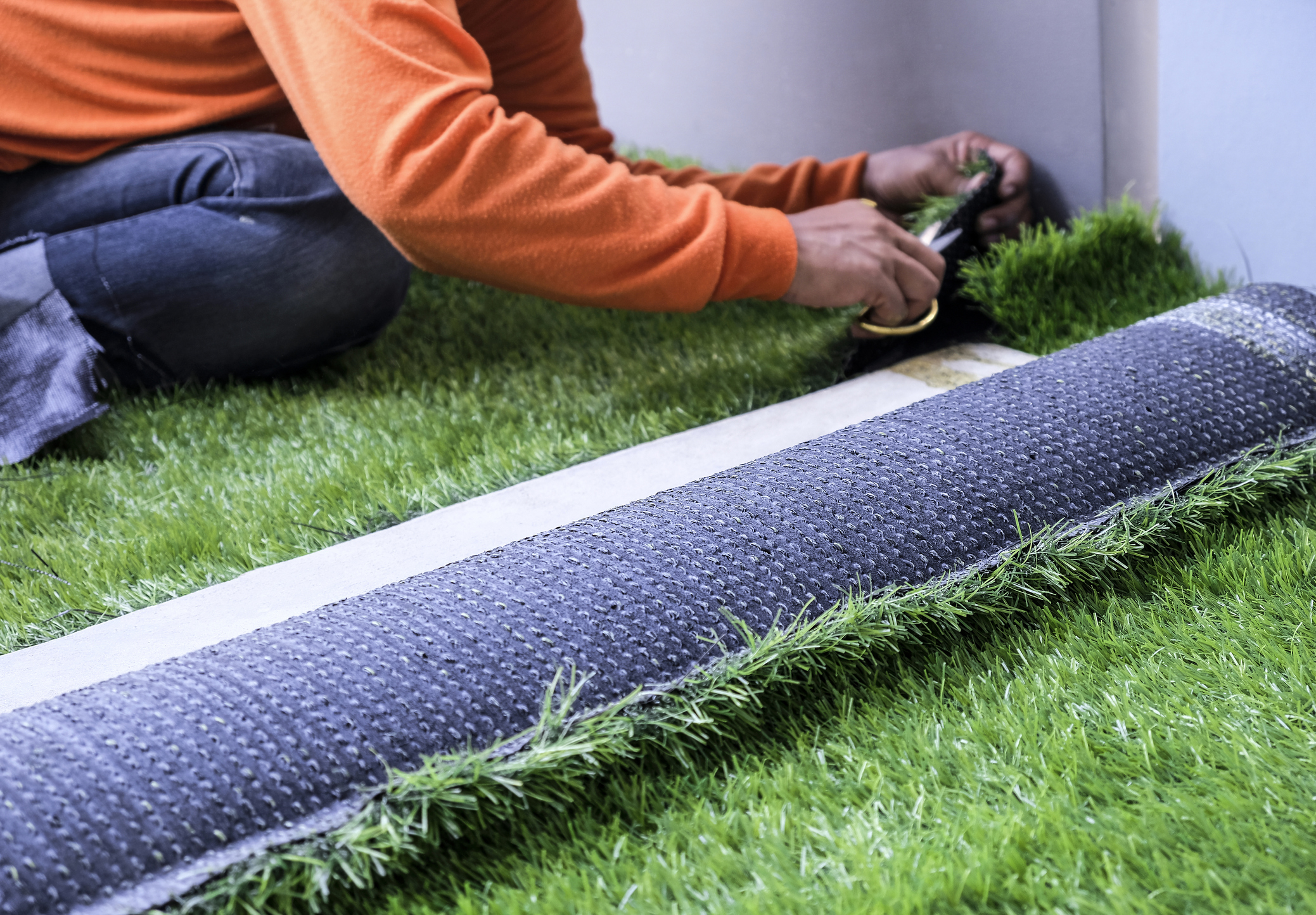 A person installing artificial turf